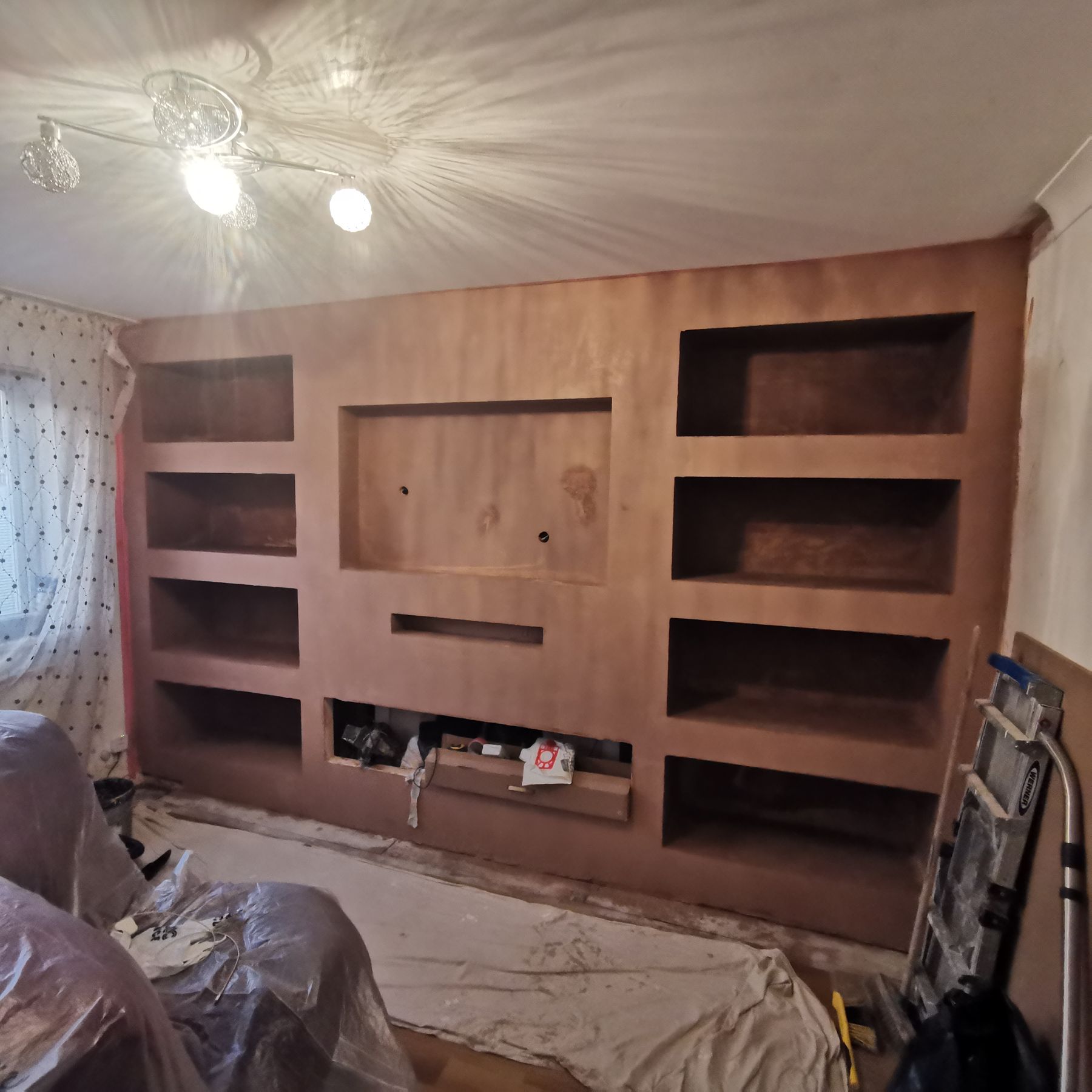 Plaster base coat of the backlit geometric media wall, before painting