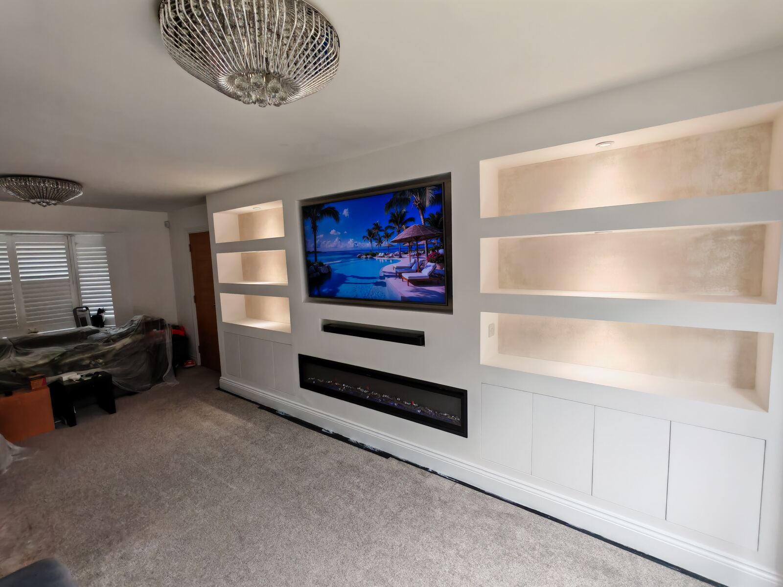Finished media wall with lit recesses and central TV housing