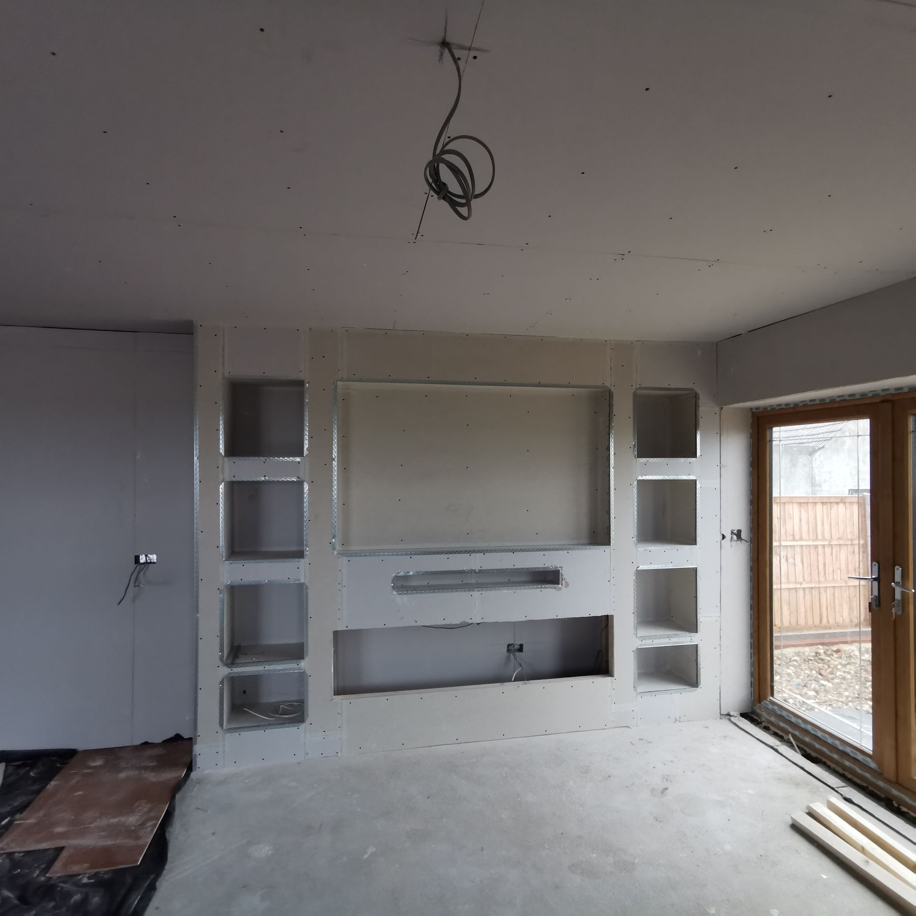 Media wall boarded with metal stud framing, before plastering