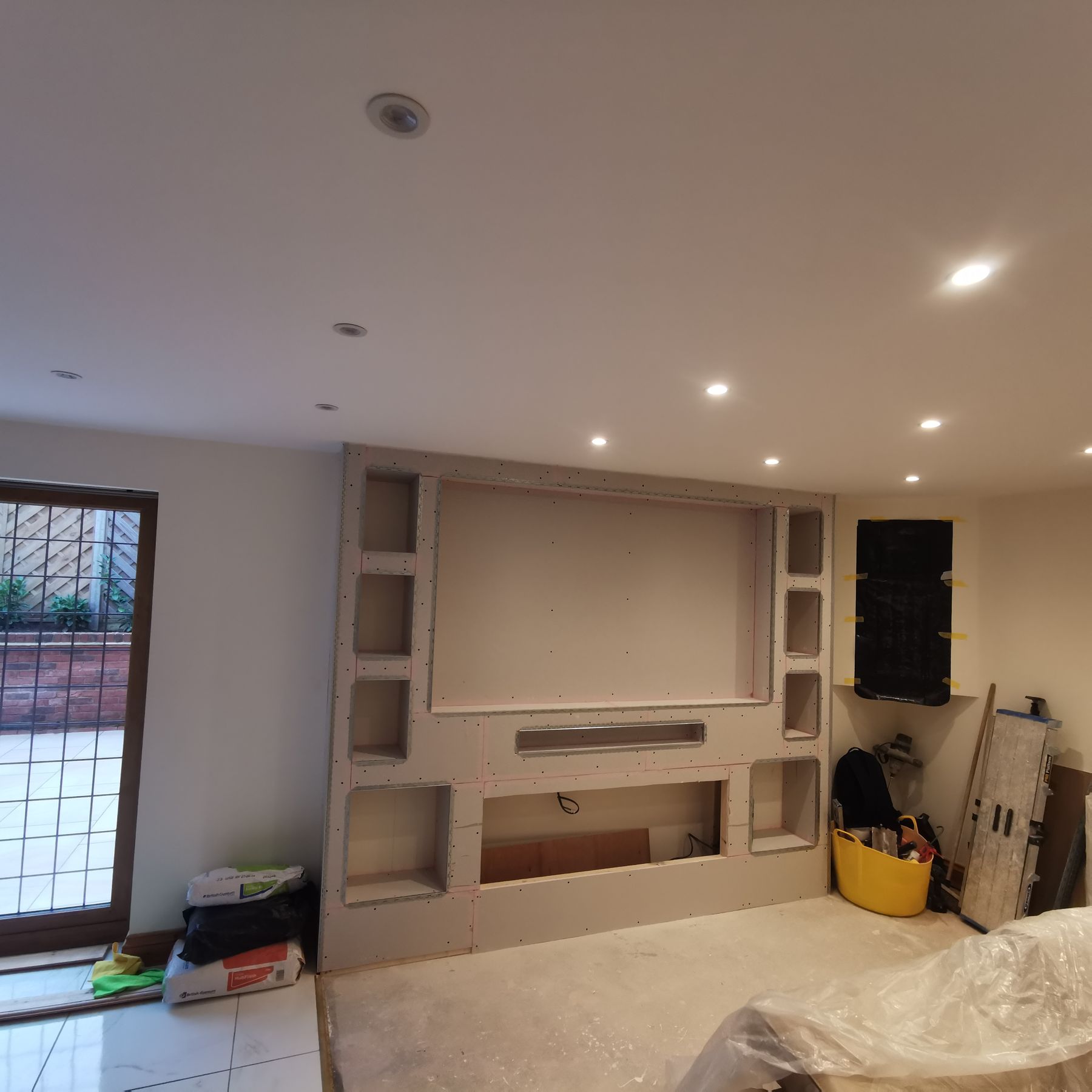 The hearth media wall boarded with metal stud framing, before plastering